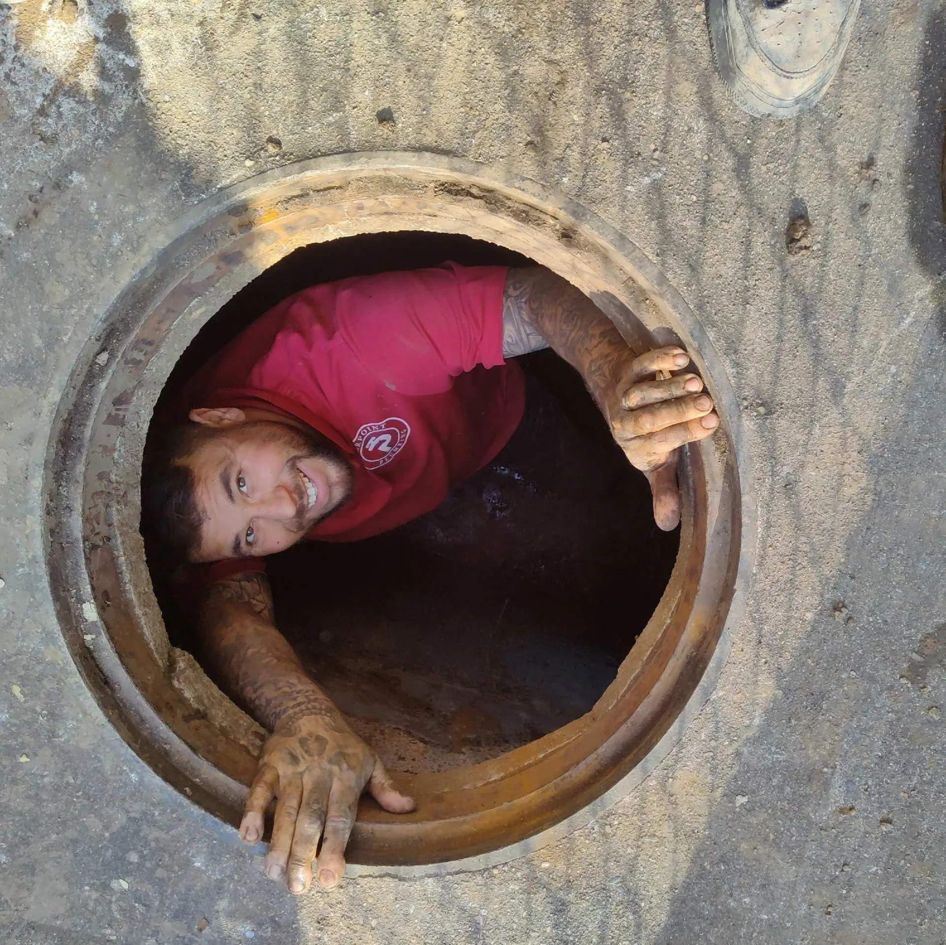 Pierpoint Plumbing technician working in a sewer manhole